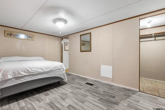 a bedroom with a bed and a painting on the wall