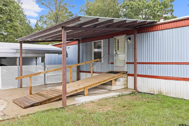 a view of backyard with deck and wooden fence