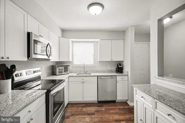 a kitchen with stainless steel appliances granite countertop a sink stove and cabinets