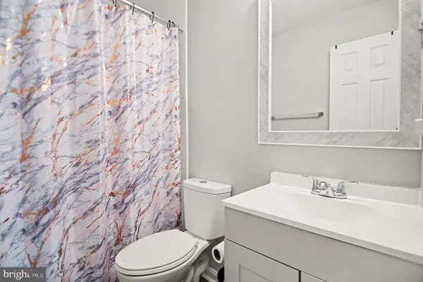 a bathroom with a sink a toilet and a mirror