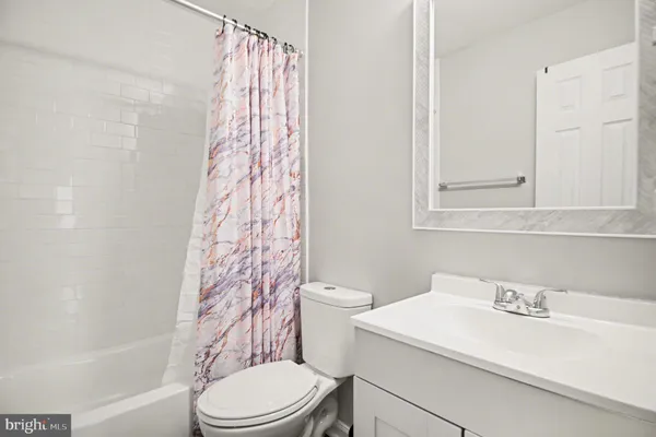 a bathroom with a sink a toilet and shower curtain