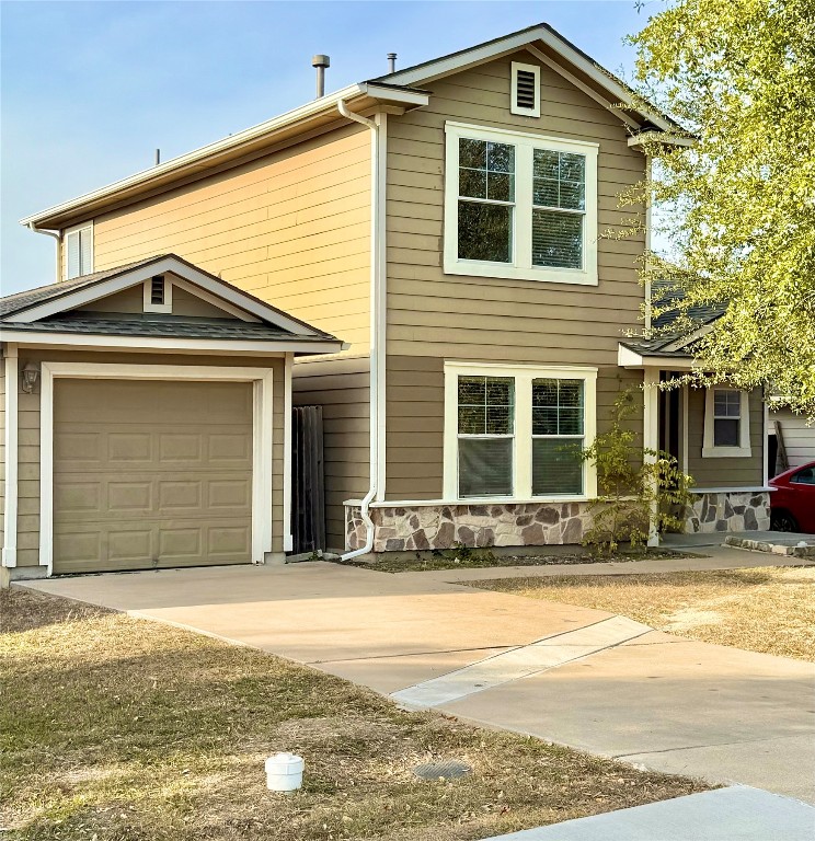 Traditional-style home featuring concrete driveway and a garage