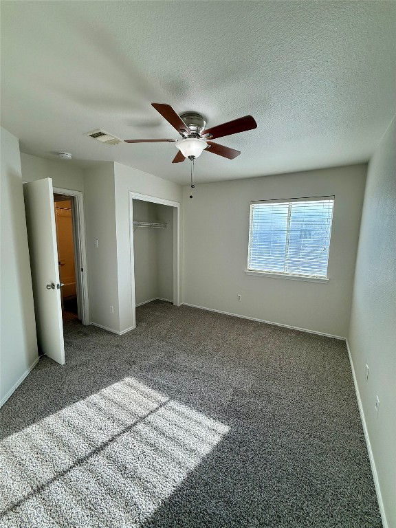 18304 Belfry Pass Manor, TX 78653 - Photo 23 of 26 Unfurnished bedroom with carpet floors, a closet, ceiling fan, and a textured ceiling