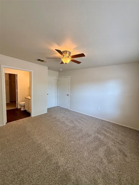 18304 Belfry Pass Manor, TX 78653 - Photo 8 of 26 Spare room featuring dark colored carpet, a textured ceiling, and a ceiling fan