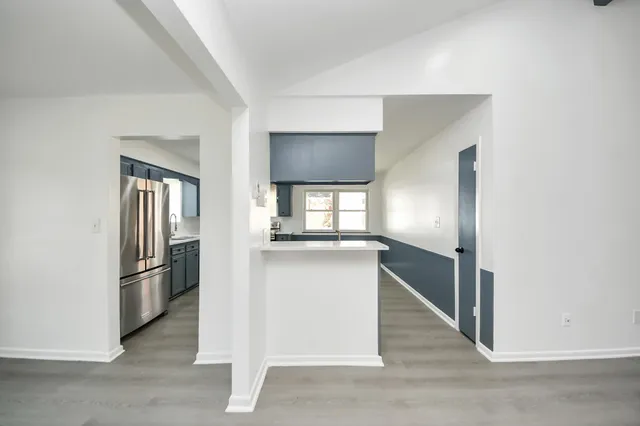 a kitchen with kitchen island a refrigerator and a stove