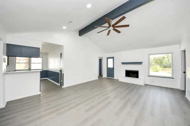 a view of empty room with wooden floor and fireplace
