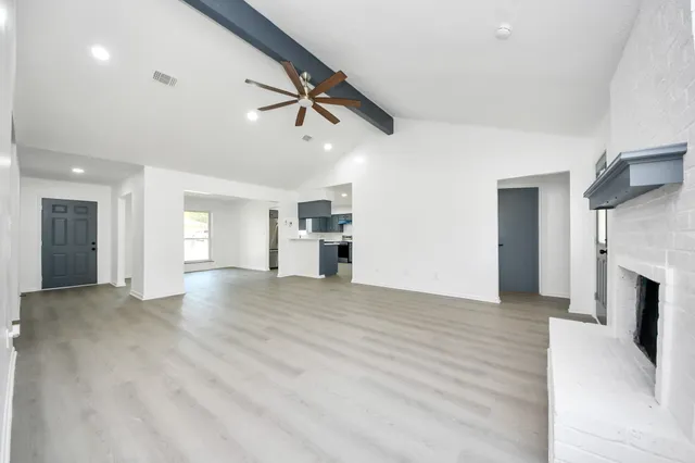 a view of empty room with a kitchen and fireplace