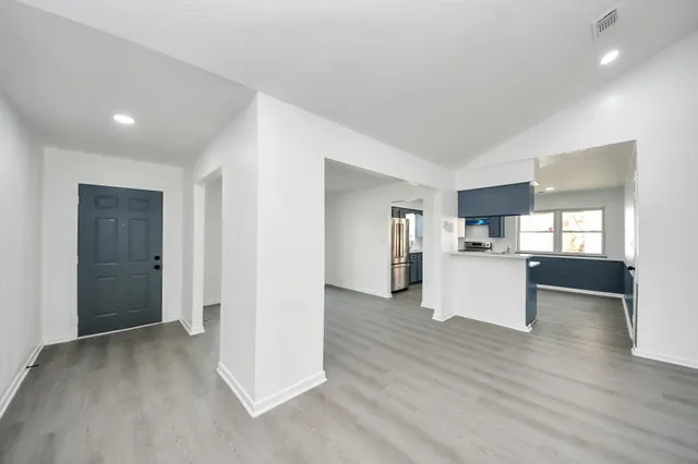 a view of empty room with wooden floor