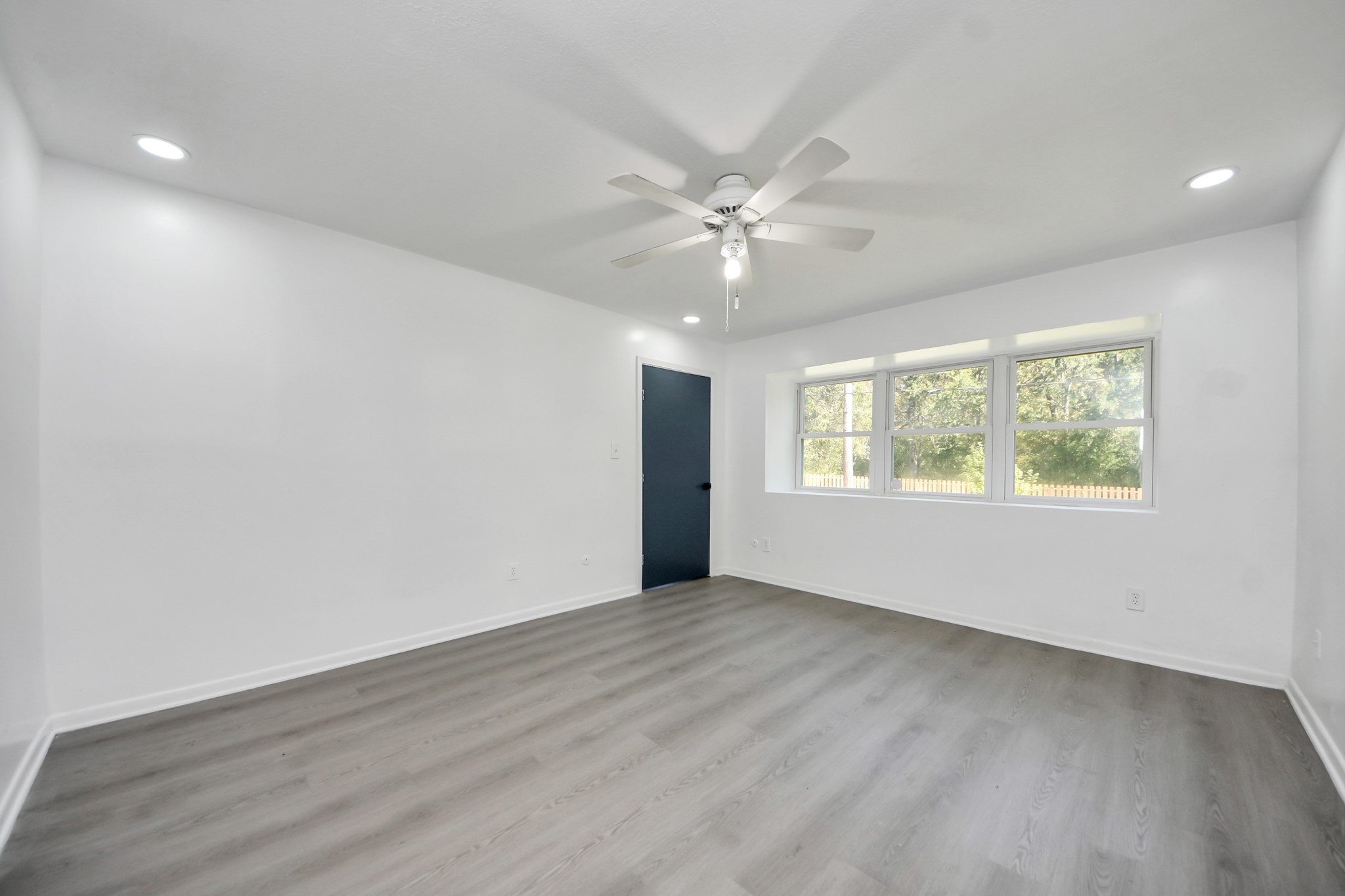 23002 Grand Rapids Lane Spring, TX 77373 - Photo 25 of 41 an empty room with wooden floor chandelier fan and windows
