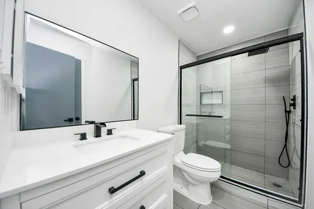 a bathroom with a sink a toilet and shower