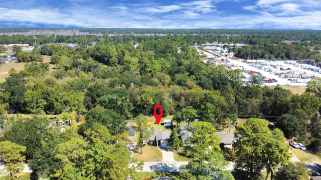 an aerial view of residential houses with outdoor space and trees