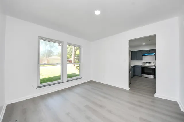 an empty room with wooden floor and a window