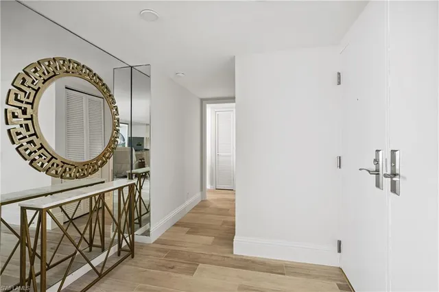 a room with a bed a mirror and a flat tv screen on dresser