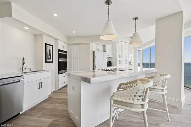 a kitchen with stainless steel appliances kitchen island granite countertop a sink and cabinets