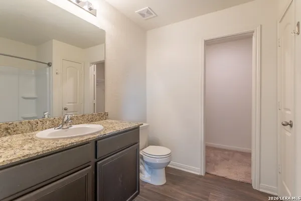 a bathroom with a granite countertop sink a mirror and a bathtub
