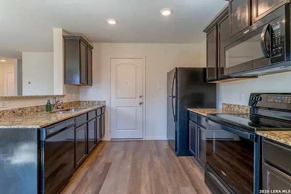 a kitchen with stainless steel appliances granite countertop a stove a refrigerator and a microwave