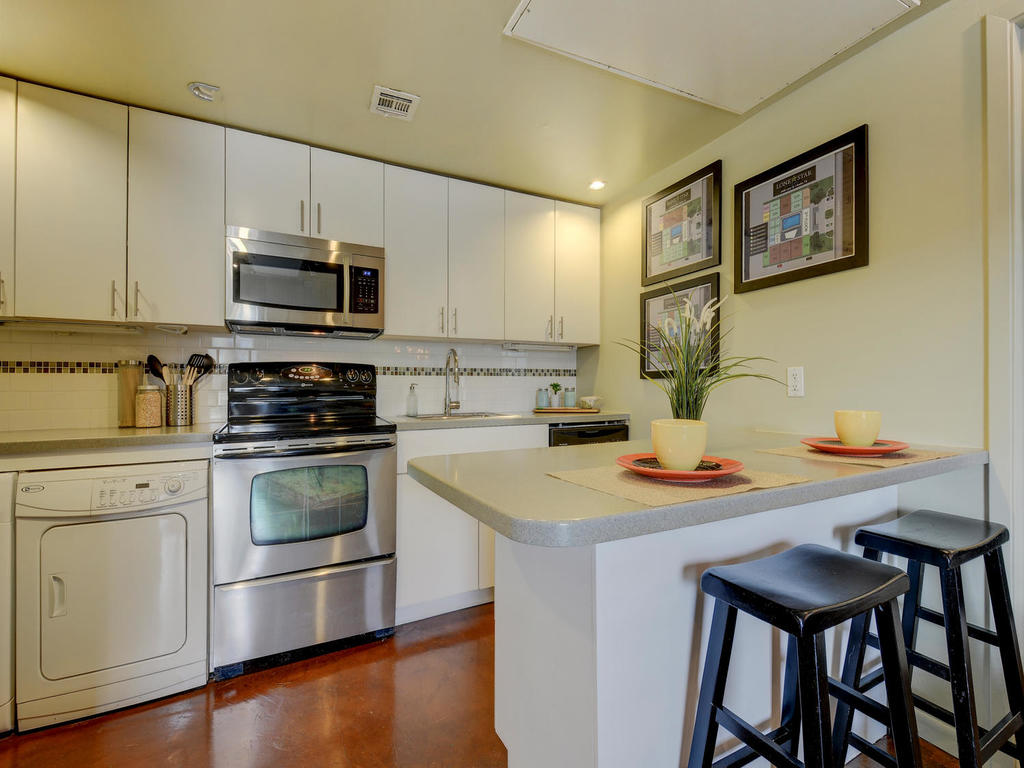 2408 Leon Street, Unit 304 Austin, TX 78705 - Photo 5 of 8 a kitchen with a stove a sink and a microwave