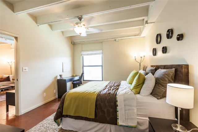 a bedroom with a bed and a lamp on the dresser