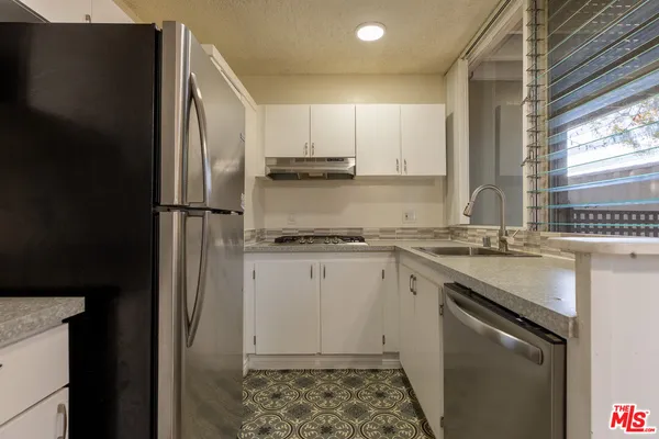 a kitchen with a refrigerator sink and cabinets