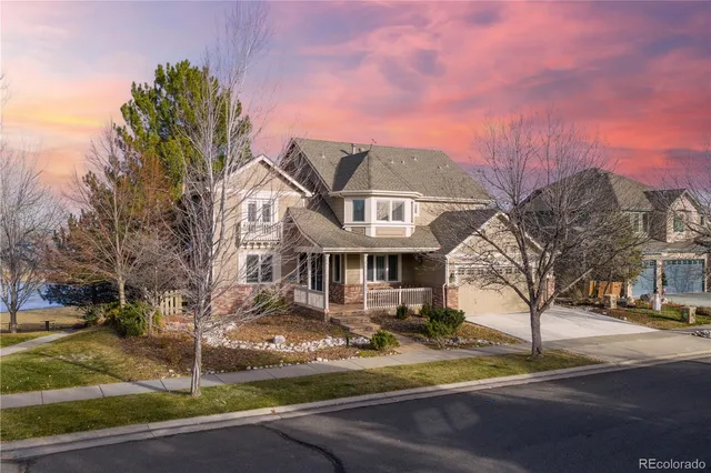 a front view of a house with street view and trees