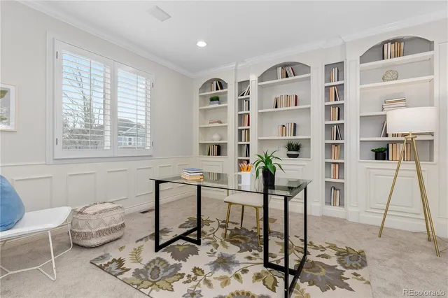 a work room with furniture a rug and white walls