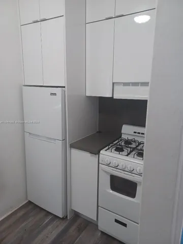 a kitchen with cabinets and white stove