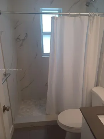 a bathroom with a shower and a toilet