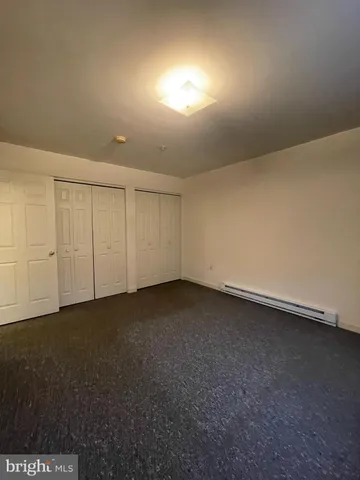 a view of an empty room and chandelier fan