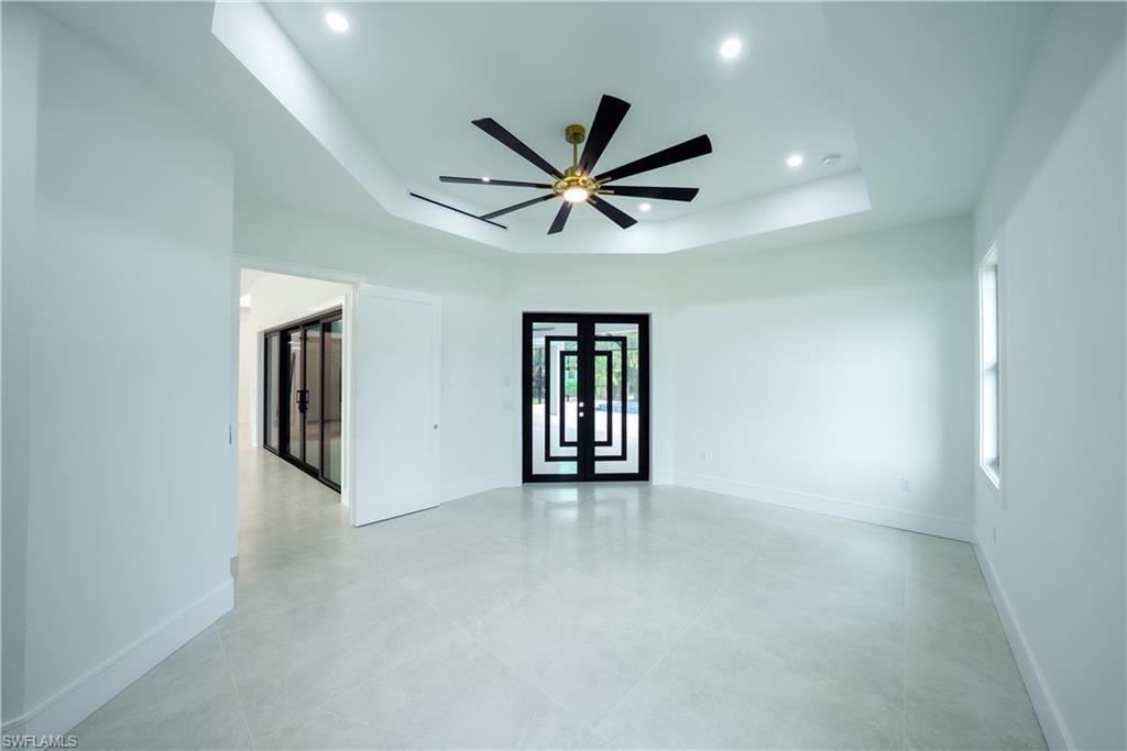 522 17th Street Southwest Naples, FL 34117 - Photo 17 of 48 an empty room with chandelier fan and windows