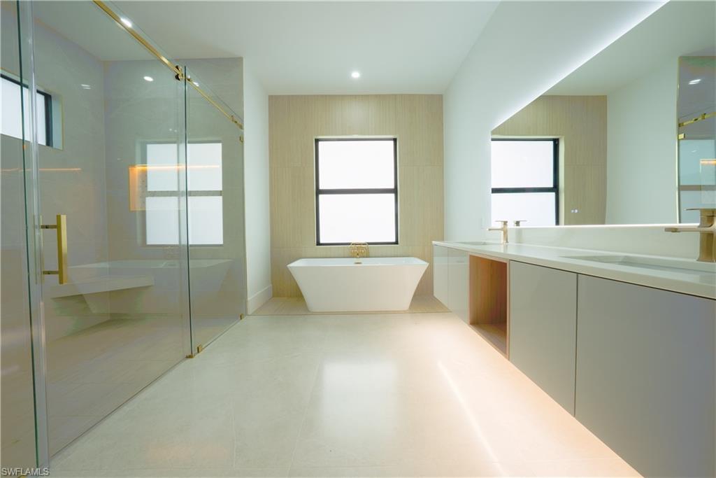 522 17th Street Southwest Naples, FL 34117 - Photo 21 of 48 a spacious bathroom with a mirror a bathtub and shower