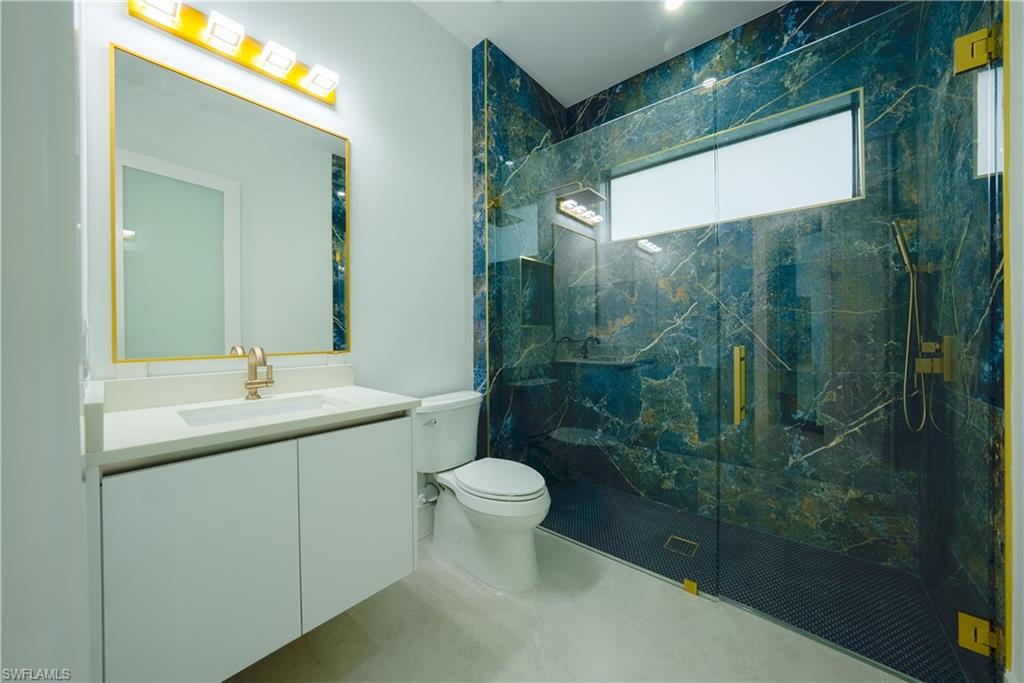 522 17th Street Southwest Naples, FL 34117 - Photo 28 of 48 a bathroom with a shower sink vanity mirror and toilet