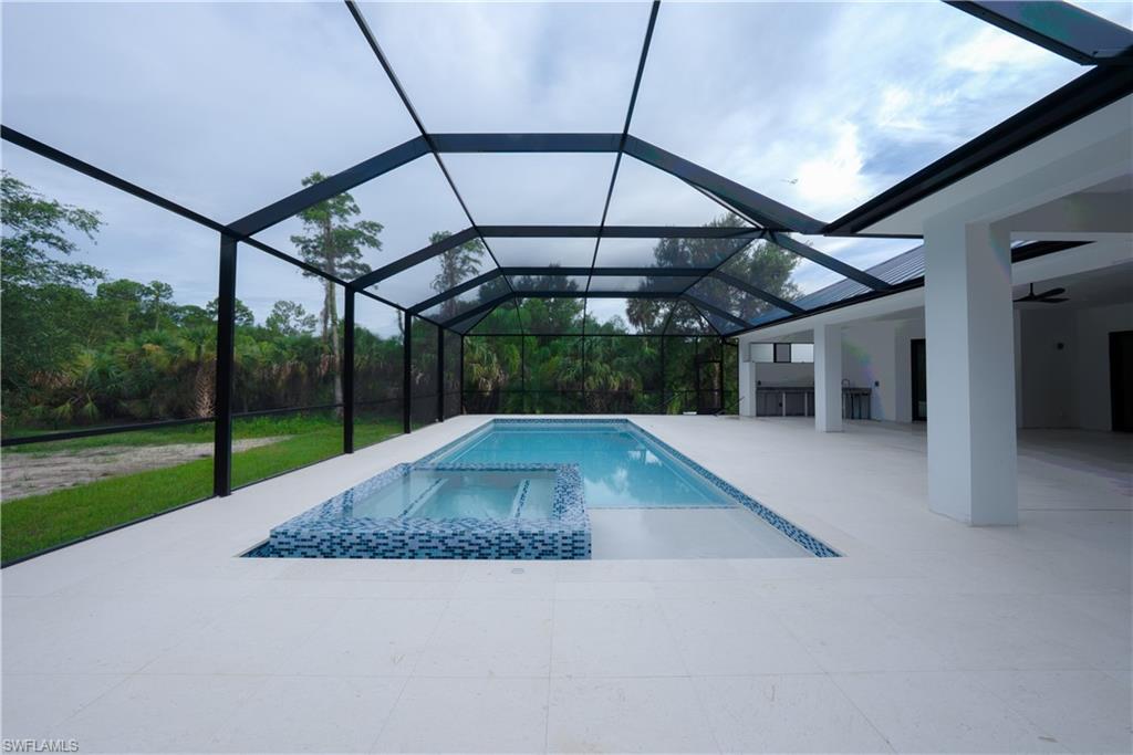 522 17th Street Southwest Naples, FL 34117 - Photo 45 of 48 a view of a backyard with table and chairs under an umbrella