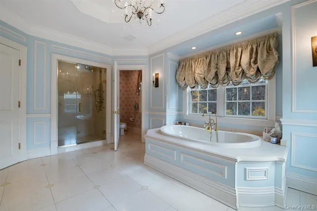 a spacious bathroom with a tub sink and mirror