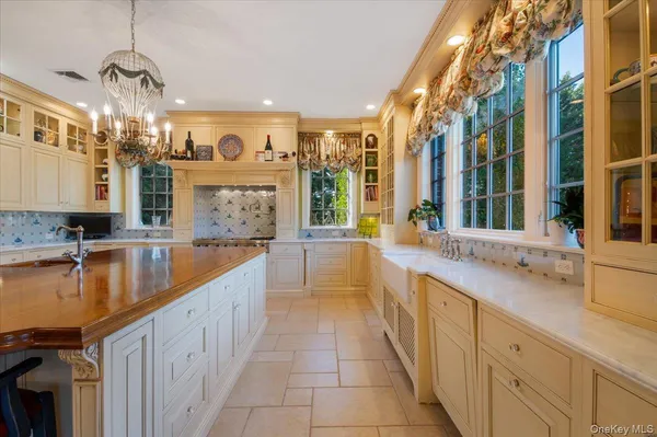 a large white kitchen with a large counter top a sink and cabinets