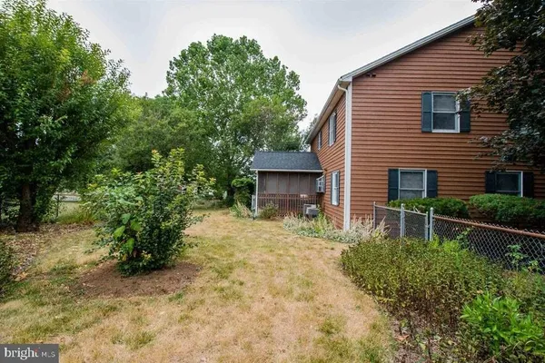 a backyard of a house with plants and tree