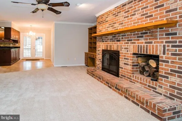 an empty room with windows and fireplace