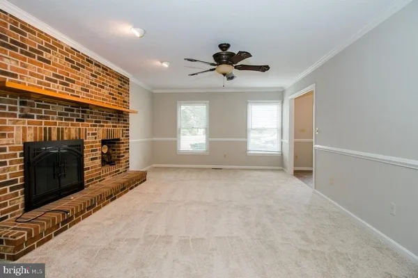 a view of an empty room with a fireplace and a window
