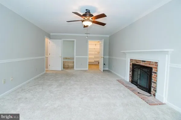 a view of a livingroom with wooden floor and a hallway