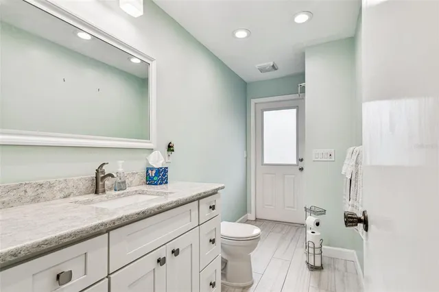 an empty room with wooden floor closet and windows