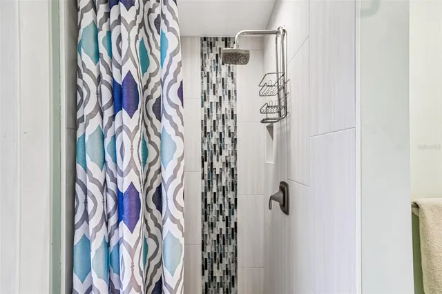 a bedroom with a large bed a flat tv screen and dresser