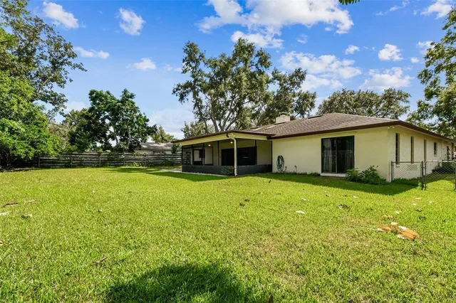 an aerial view of residential houses with outdoor space and trees