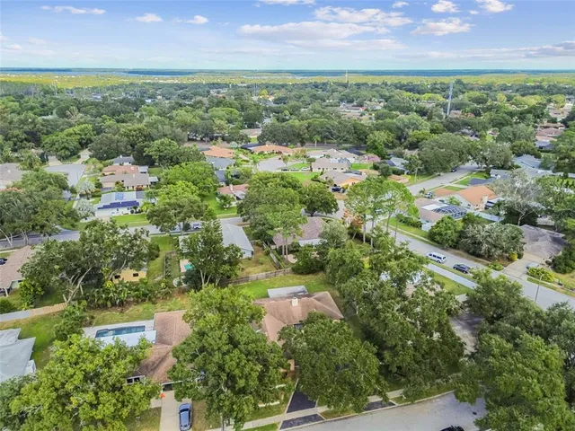 a sign that is sitting in front of a house with a big yard