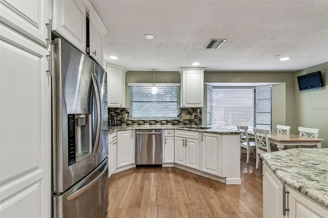 a kitchen with stainless steel appliances granite countertop a refrigerator and a stove