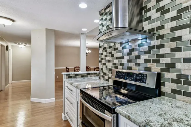 a kitchen with stainless steel appliances kitchen island granite countertop a sink and a microwave