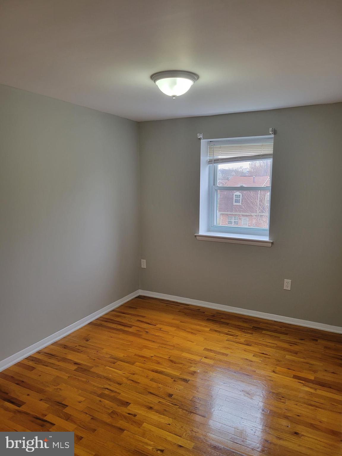 630 Kingston Road Baltimore, MD 21220 - Photo 22 of 34 a view of an empty room with wooden floor and a window