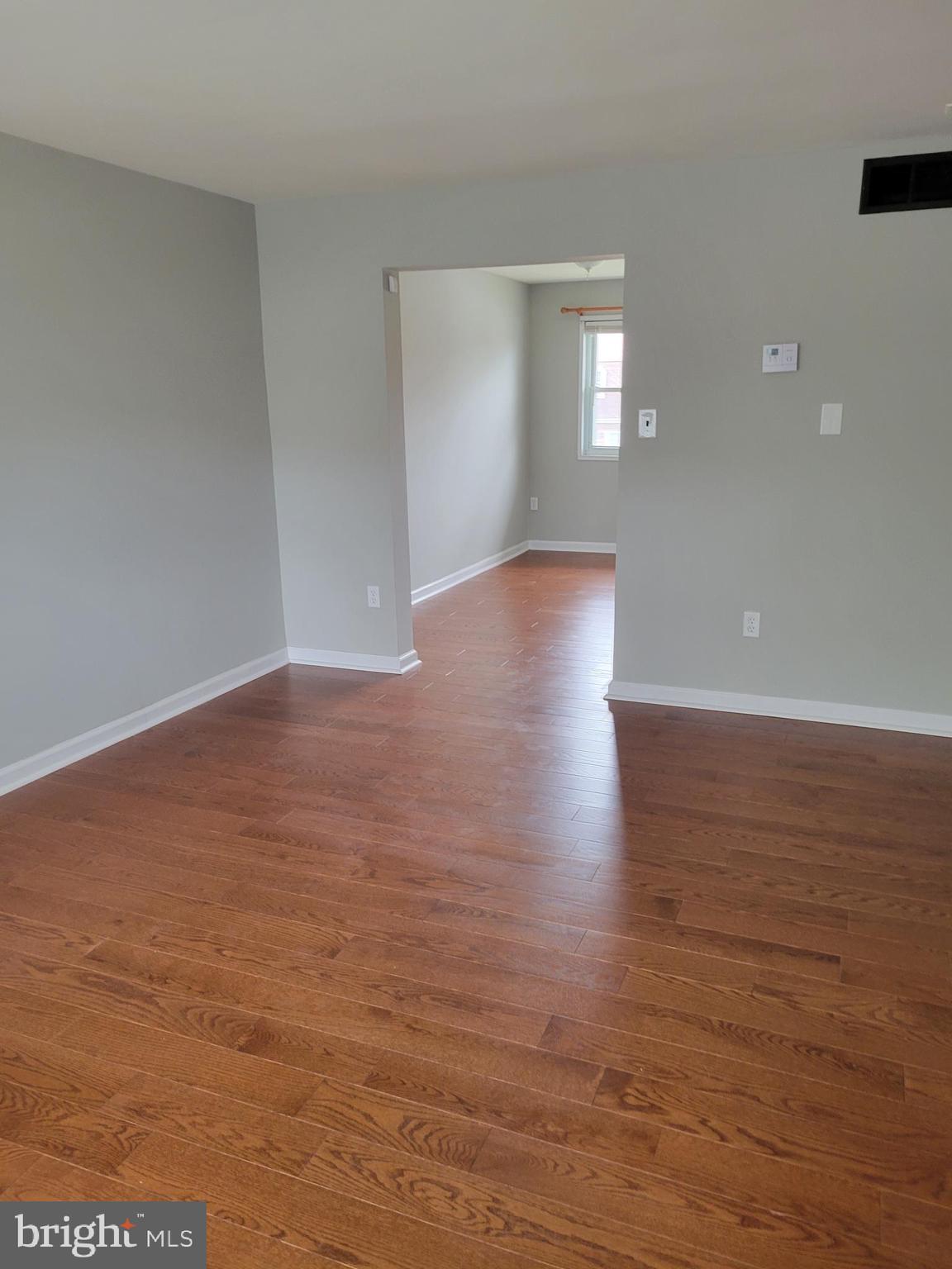 630 Kingston Road Baltimore, MD 21220 - Photo 4 of 34 a view of an empty room with wooden floor and a window