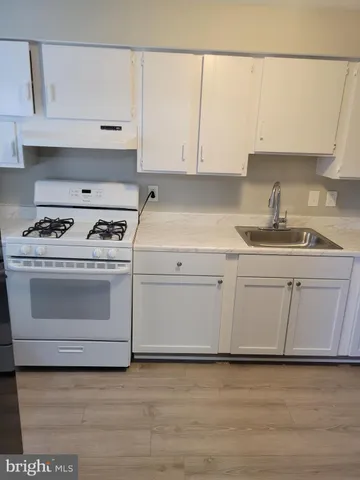 a kitchen with granite countertop white cabinets and white appliances