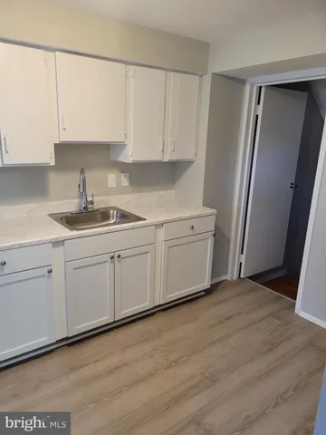 a white kitchen with sink and cabinets