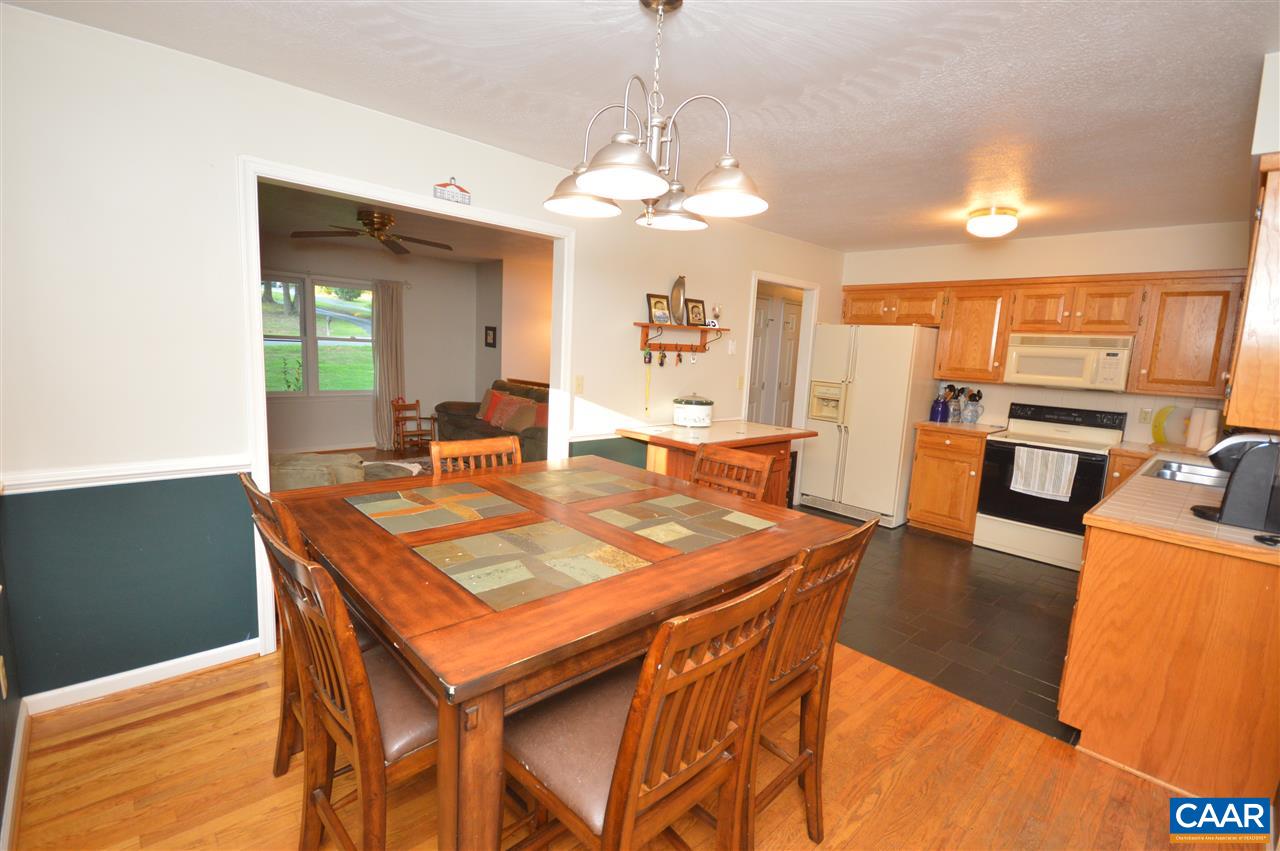 389 Morning Glory Road Ruckersville, VA 22968 - Photo 6 of 34 a dining room with wooden floor a chandelier a wooden table and chairs