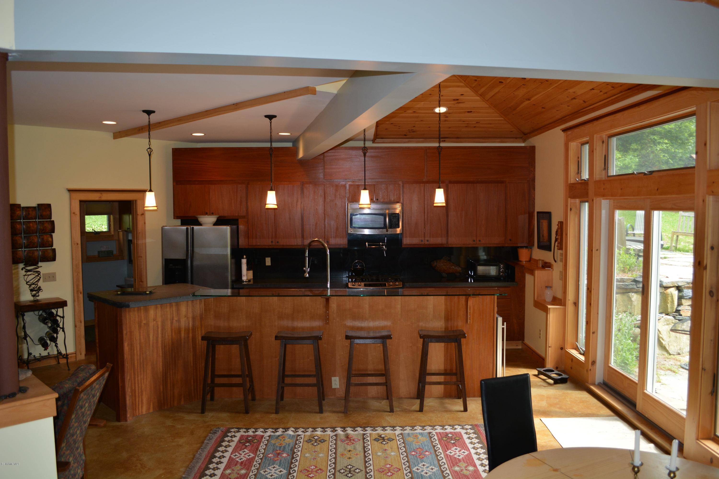 317 Pine Road Otis, MA 01029 - Photo 5 of 27 a room with stainless steel appliances lots of wooden furniture dining table and chairs
